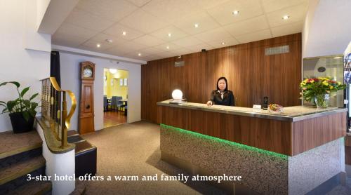 a woman sitting at a reception desk in a hotel at Hôtel Bellerive in Lausanne