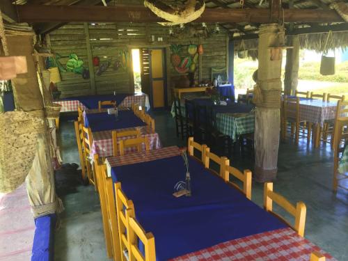 een restaurant met tafels en stoelen in een kamer bij Los Bohios Campo Añil in Jarabacoa