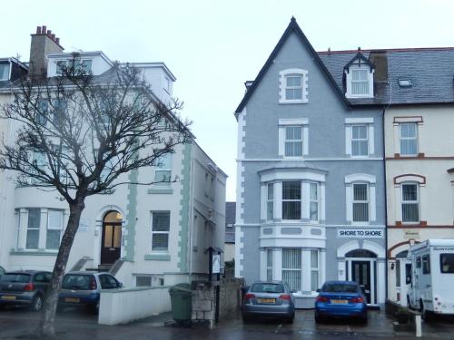 a group of buildings with cars parked in a parking lot at Shore to Shore in Llandudno