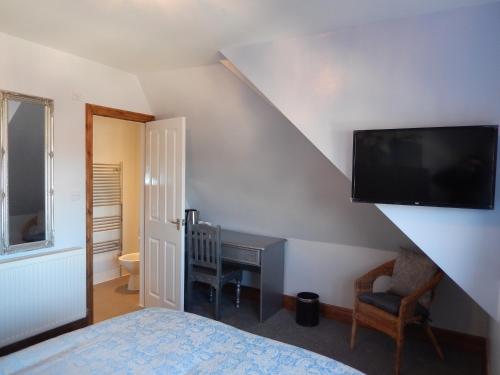 a bedroom with a bed and a tv on the wall at Shore to Shore in Llandudno