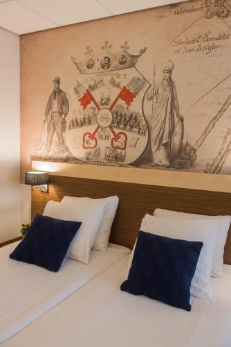 a bedroom with two beds with a painting on the wall at Tulip Inn Leiden Centre in Leiden