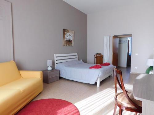 ナポリにあるCasa Anteaのベッドルーム(白いベッド1台、ソファ付)