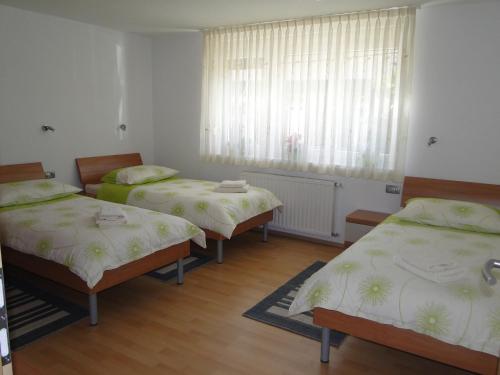 a room with three beds and a window at Apartma Jezero in Most na Soči