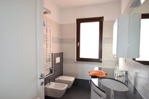 bagno con lavandino, servizi igienici e finestra di CASA ELENA 2 a Germignaga