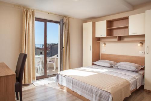 a bedroom with a bed and a large window at Apartments Kate in Makarska