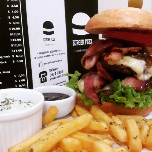 a hamburger and french fries on a plate at Flex Hotel in Canoinhas
