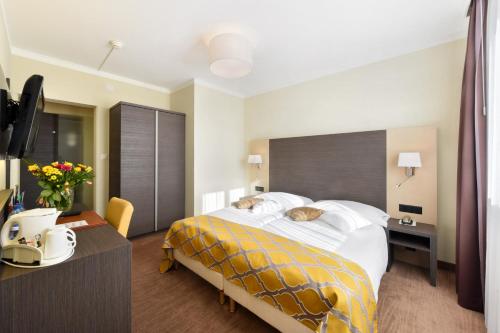 a hotel room with a large bed and a desk at Hôtel Bellerive in Lausanne