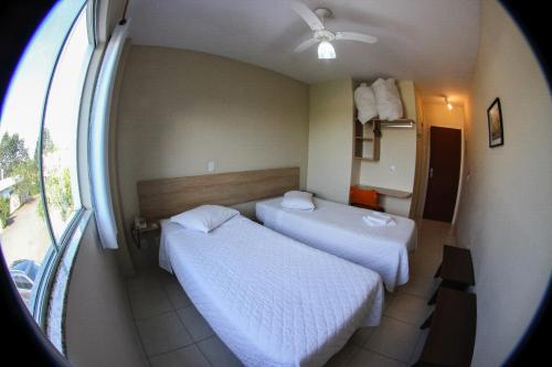 a hotel room with two beds and a window at Flex Hotel in Canoinhas