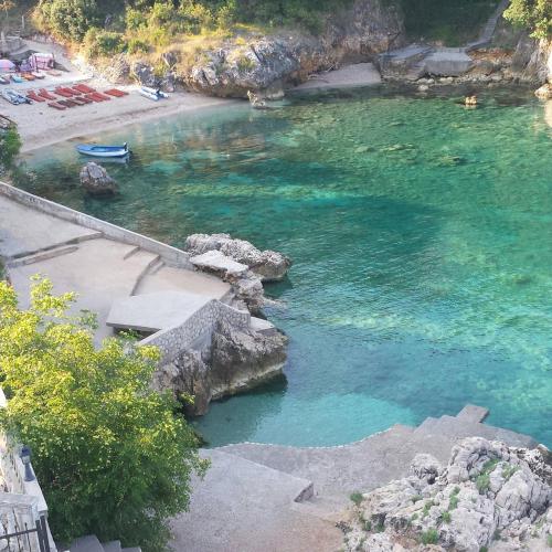a body of water with rocks and a beach at Apartments Misko in Utjeha