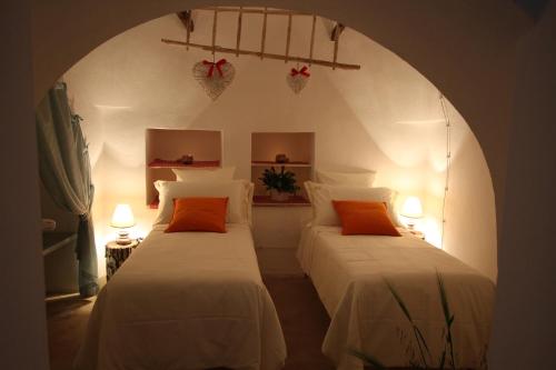 アルベロベッロにあるSuite del Vicoのアーチ道のある部屋のベッド2台