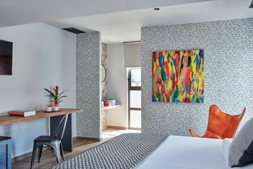 - une chambre avec un lit et une peinture murale dans l'établissement 18 Micon Str., à Athènes