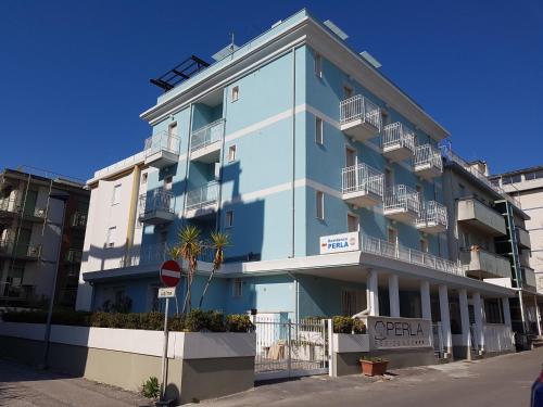 ein blaues Gebäude mit Balkonen auf einer Straße in der Unterkunft Residence Perla in Rimini