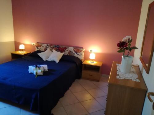 a bedroom with a blue bed with two lamps at Profumo di Mare Fronte Spiaggia in Noto Marina