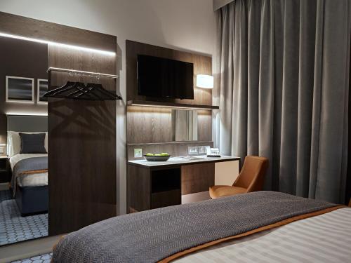 una camera d'albergo con letto e scrivania di Best Western Plus Vauxhall Hotel a Londra