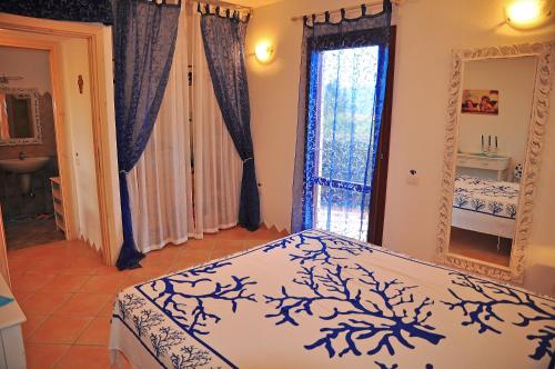 een slaapkamer met een bed en een spiegel bij Villino Belvedere in Budoni