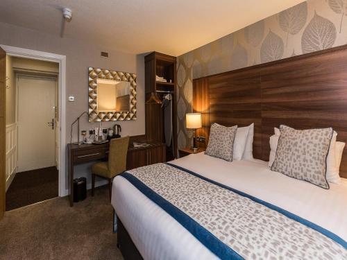 a hotel room with a bed and a desk at The Melbreak Hotel in Great Clifton