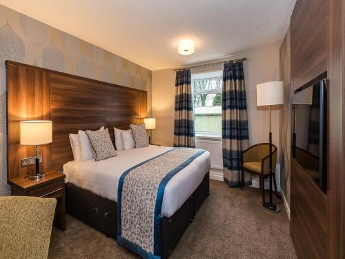 a hotel room with a bed and a television at The Melbreak Hotel in Great Clifton