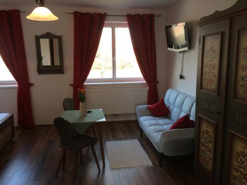 a living room with a couch and a tv at Pension Marillenhof in Melk