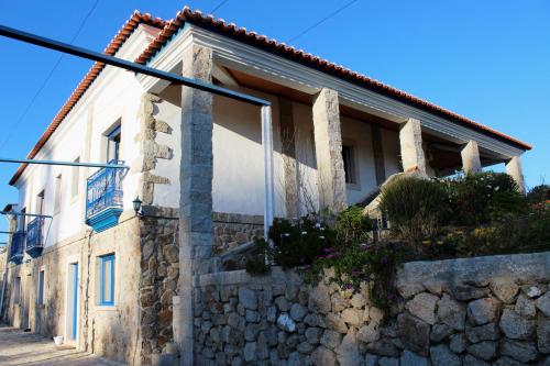 a house on the side of a stone wall at Quinta Ribeiro Tanquinhos in Tancos