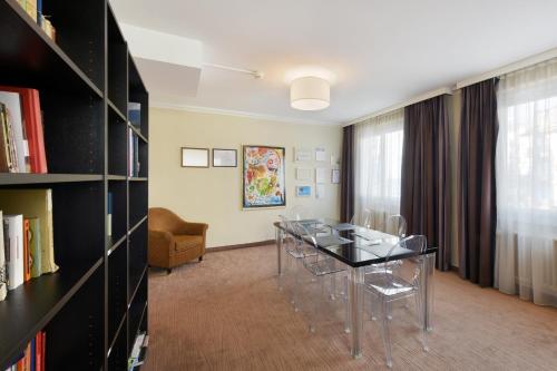 a dining room with a table and a book shelf at Hôtel Bellerive in Lausanne