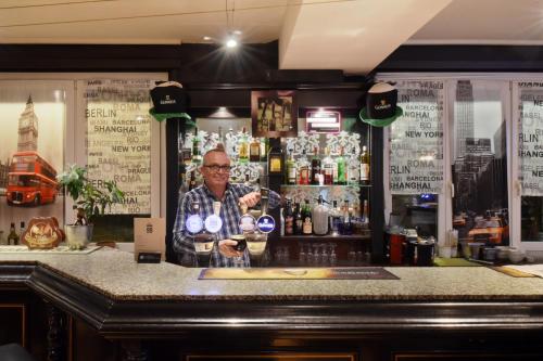 a man standing behind a bar with a glass of wine at Hôtel Bellerive in Lausanne