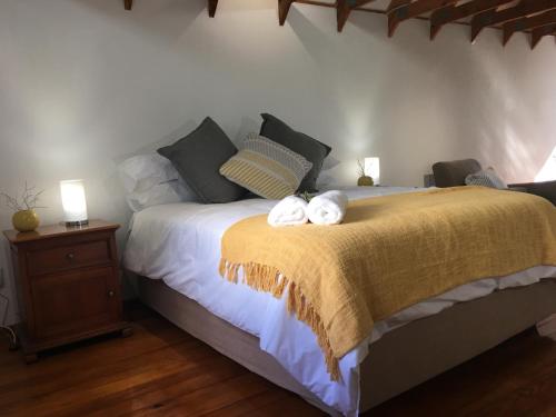 a bedroom with a bed with two towels on it at Cuckoos Nest Guest House in Louis Trichardt