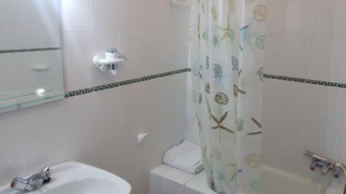a bathroom with a sink and a shower curtain at Apartamento Zulema in Aracena