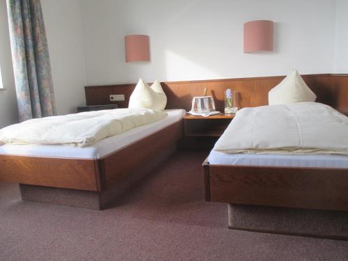 two twin beds in a room with at Adler Golf-& Tagungshotel in Harth - Pöllnitz
