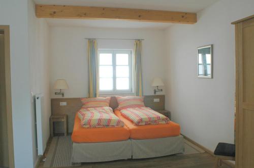 a bedroom with a bed with pillows and a window at Ferienhaus am Brunnen in Tiefenpölz