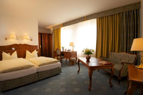 A bed or beds in a room at Adler Golf-& Tagungshotel
