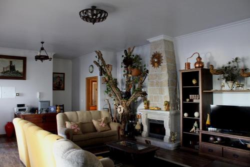 a living room with a couch and a fireplace at Quinta Ribeiro Tanquinhos in Tancos