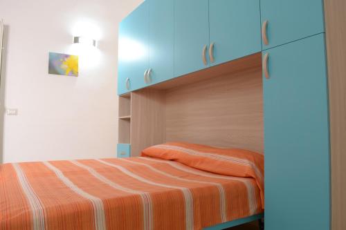 マティーノにあるLa Terra del Sole Casa privata per vacanzeのベッドルーム1室(オレンジ色のストライプ毛布付きのベッド1台付)