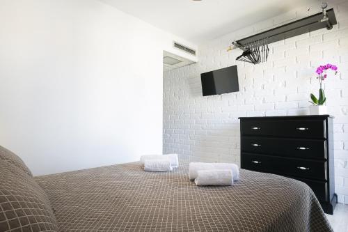 um quarto com uma cama, uma cómoda e uma televisão em Hotel Montmar em Roses