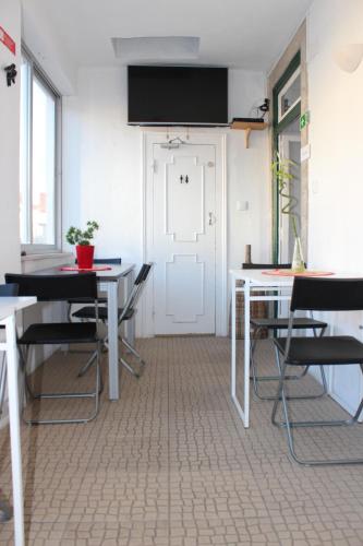 a room with tables and chairs and a white door at Hostel Seven Hills in Lisbon