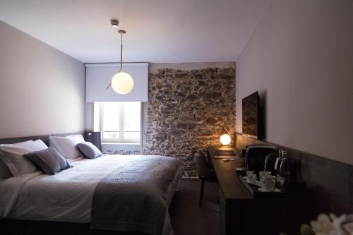 a bedroom with a bed and a desk and a window at Etoile de Pompadour in Arnac-Pompadour