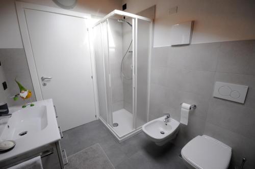 a bathroom with a shower and a toilet and a sink at Appartamenti Ochner in Pergine Valsugana
