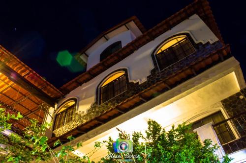 a building with three windows on it at night at Hotel & Restaurant Fleur de Lis in Concepción de Ataco