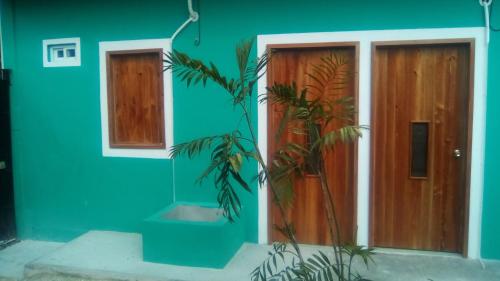 a blue house with a wooden door and a plant at Hotel Chaac Calakmul in Xpujil