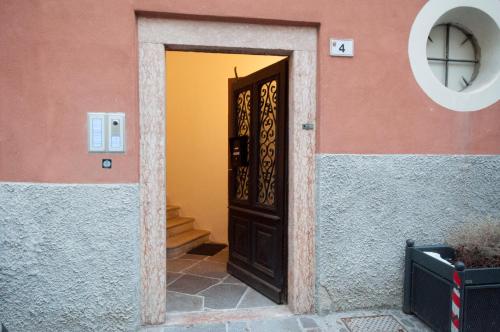 a door to a house with a pink and yellow wall at Appartamenti Ochner in Pergine Valsugana