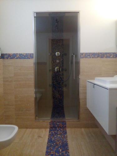 a shower with a glass door in a bathroom at Relais Villa Lézard in Colà di Lazise