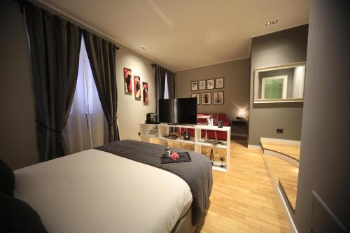 um quarto com uma cama e uma televisão em K Rooms em Roma