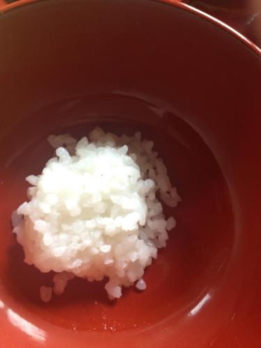a bowl of white rice in a sauce at 富山県 よしのや旅館 in Nanto