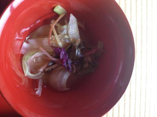 a red bowl of food with vegetables in it at 富山県 よしのや旅館 in Nanto