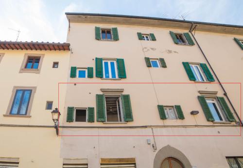 a tall building with green shutters on it at Agnolo in Florence