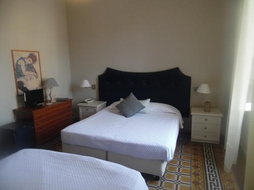 a bedroom with two beds and two night stands at Hotel Miramare in Lavagna