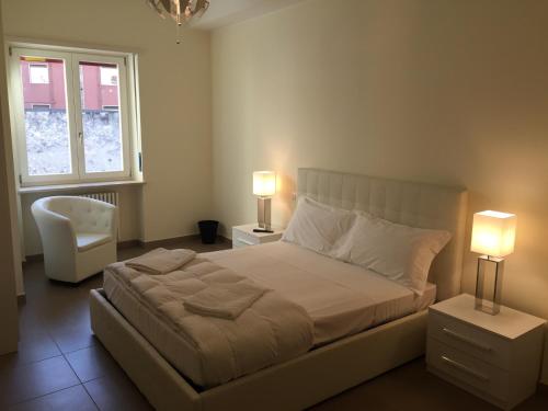 a bedroom with a bed with two lamps and a chair at 3Jolie Rooms in Verona