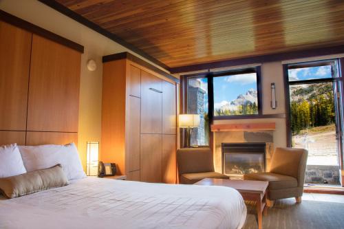 a bedroom with a large bed and a fireplace at Sunshine Mountain Lodge in Banff