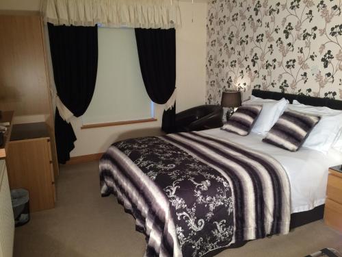 a bedroom with a bed with a black and white blanket at Glen-Lyn in Robin Hood's Bay