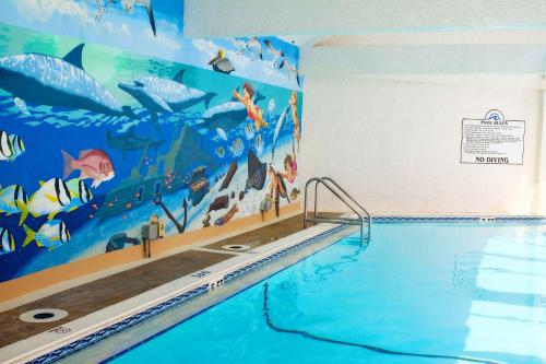 a swimming pool with a mural of an aquarium at Landmark Holiday Beach, a VRI resort in Panama City Beach