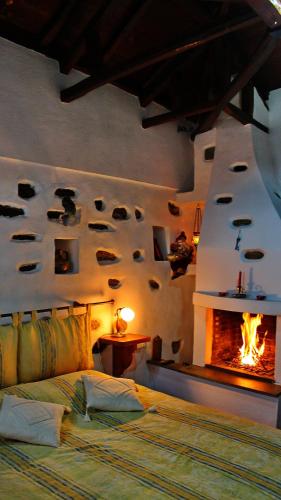 a bedroom with a bed and a fireplace at Archontiko Stafylopati in Makrinitsa